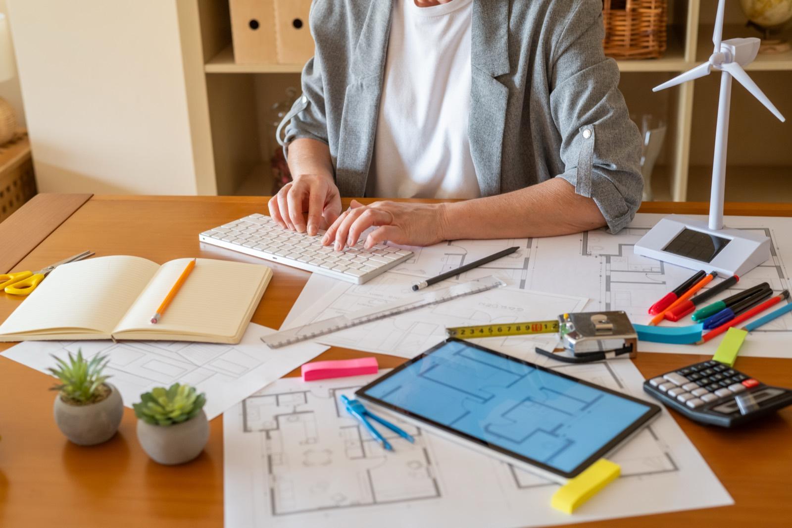 Puesto de trabajo con planos, tableta y maqueta de aerogenerador
