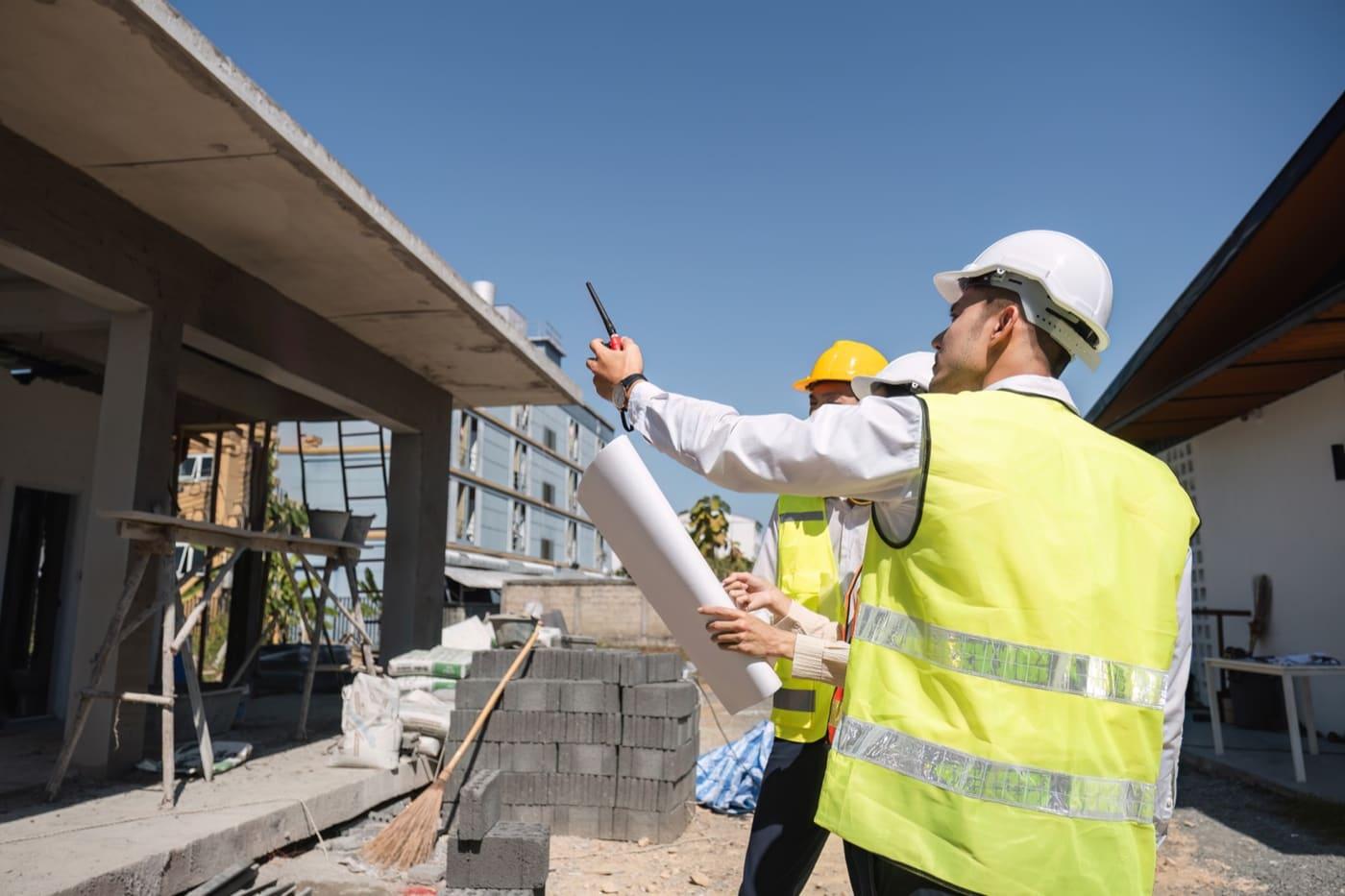 Two site technicians checking progress from the scaffolding