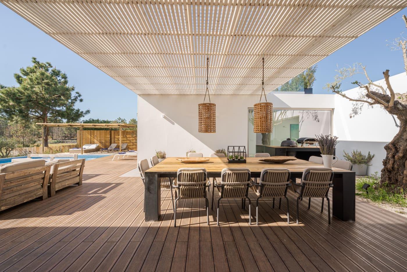 Timber pergola over the outdoor dining area, among olive trees