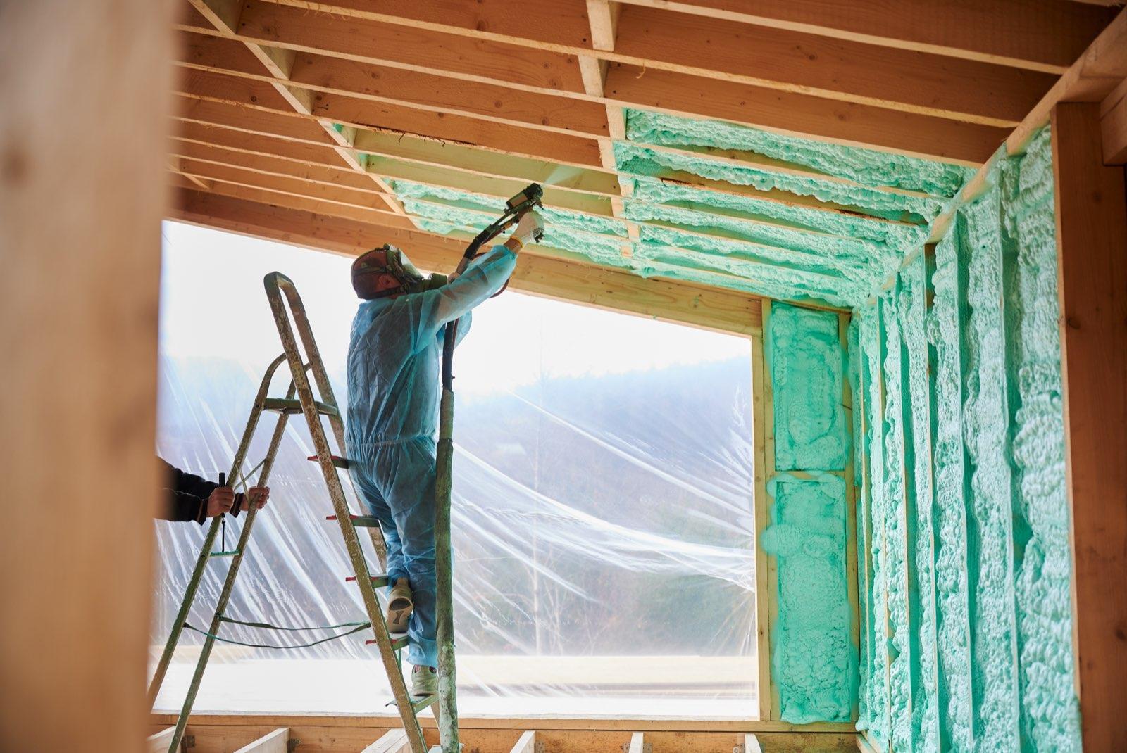 Operario proyectando aislamiento sobre la envolvente de madera