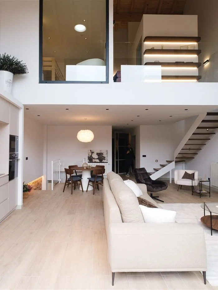 Salón diáfano de doble altura en vivienda reformada